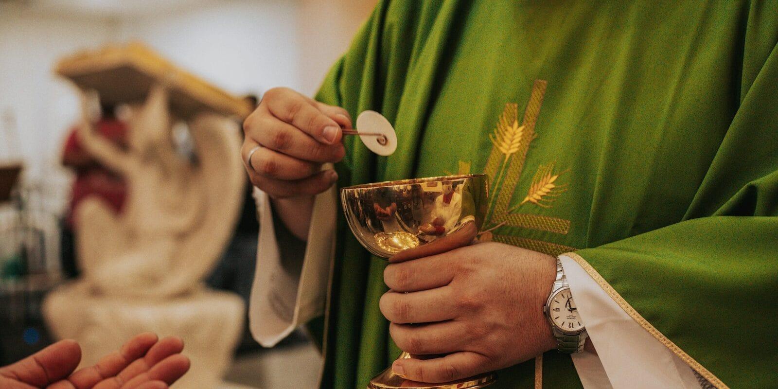 person in green long sleeve shirt holding clear drinking glass